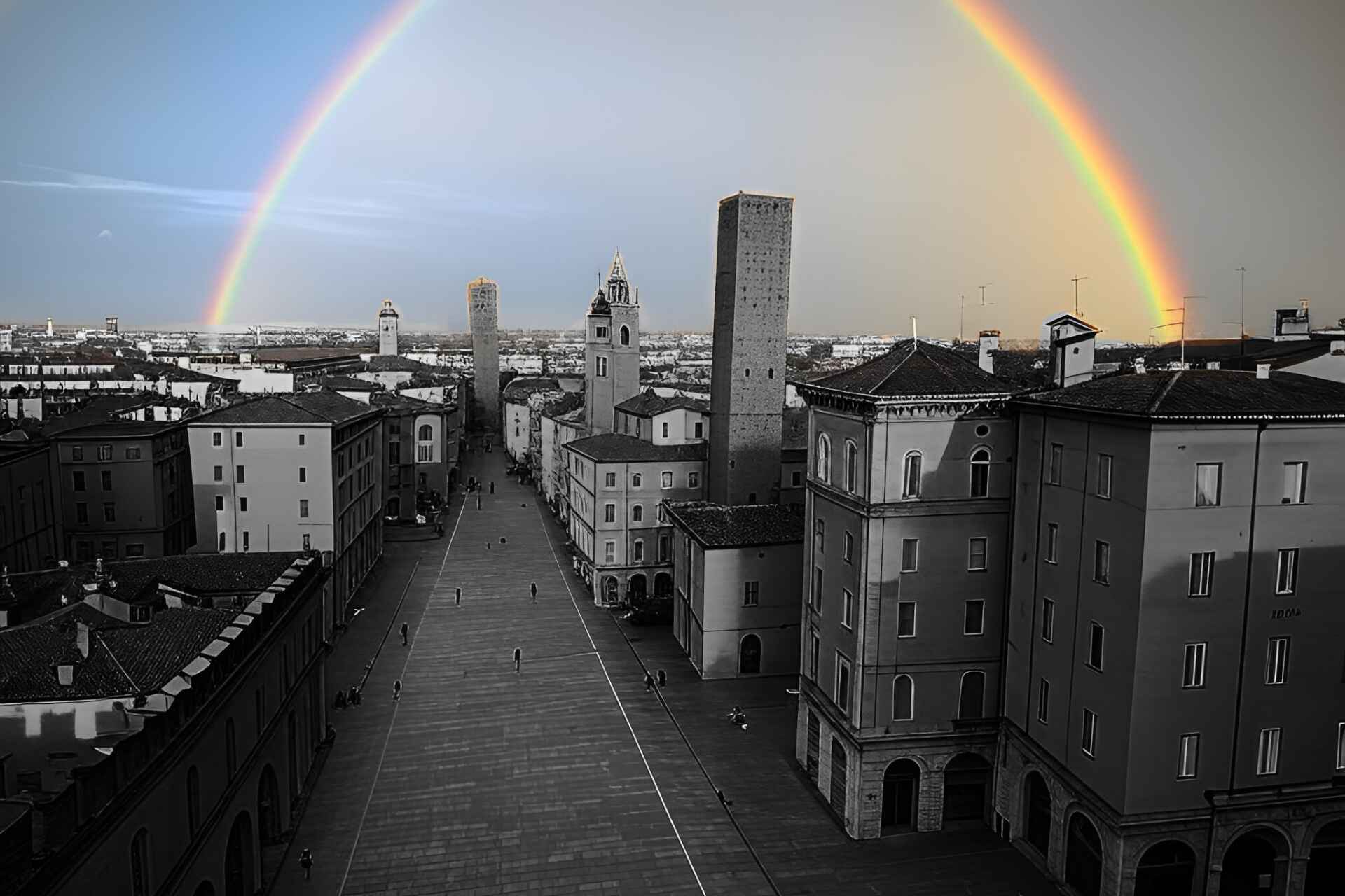 Arcobaleno sopra le Due Torri di Bologna, simbolo di trasparenza e opportunità immobiliari.