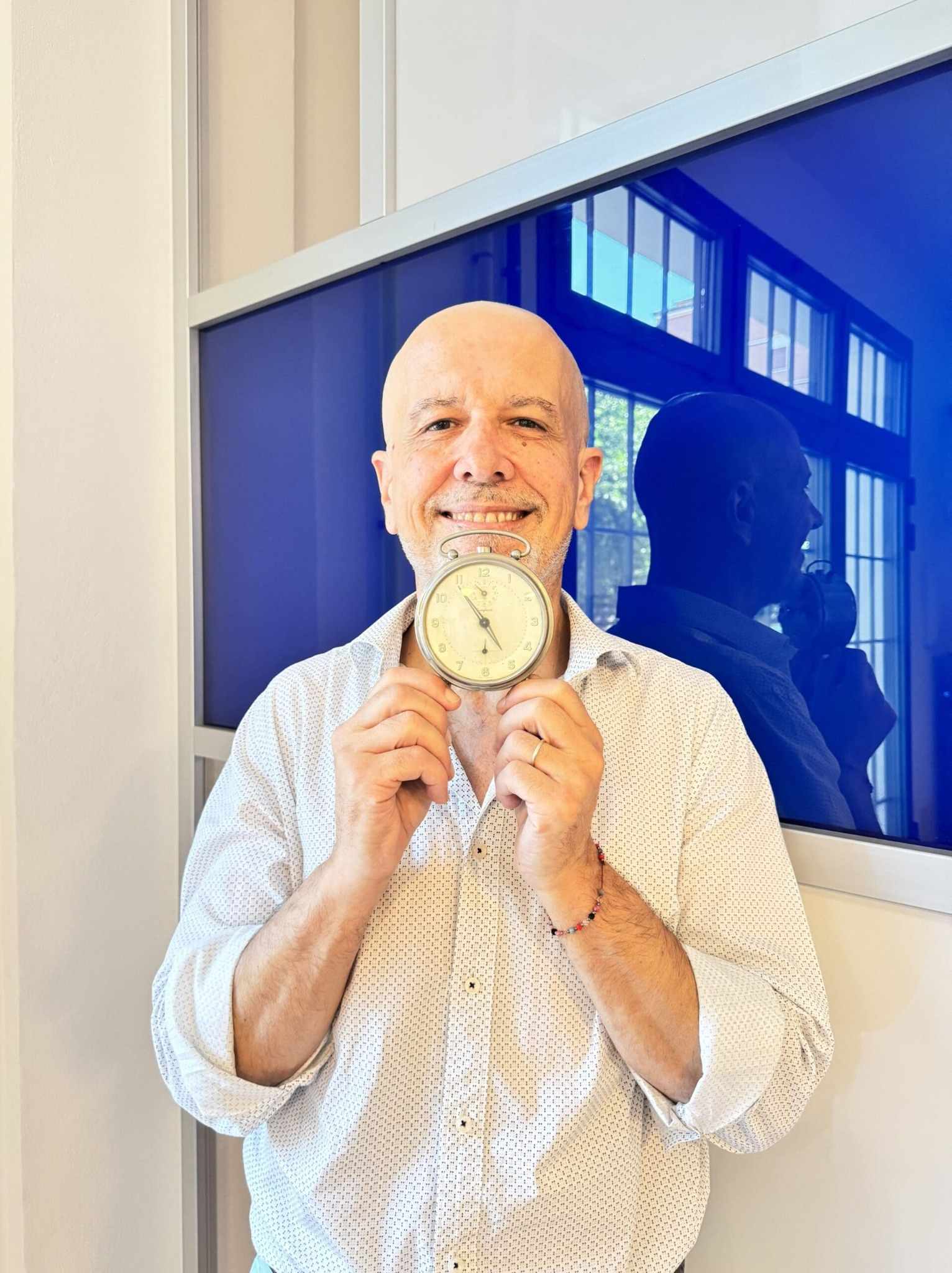 Luigi Benedetti, agente immobiliare senior e titolare di DesiderataDomus a Bologna, con orologio in mano.