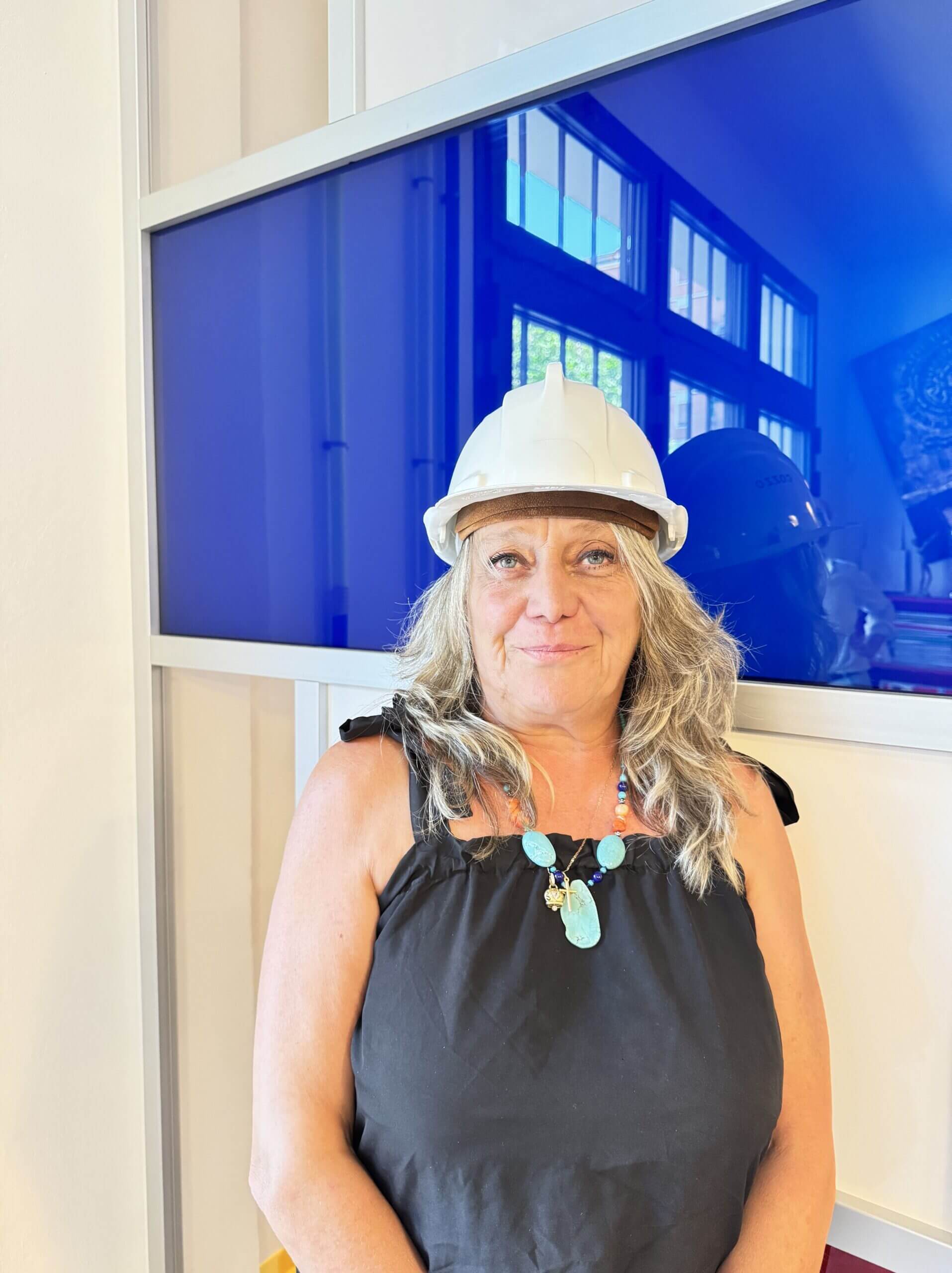 Lisa Torchi, agente immobiliare a Bologna, con casco da cantiere simbolo di attenzione e cura nelle transazioni immobiliari.