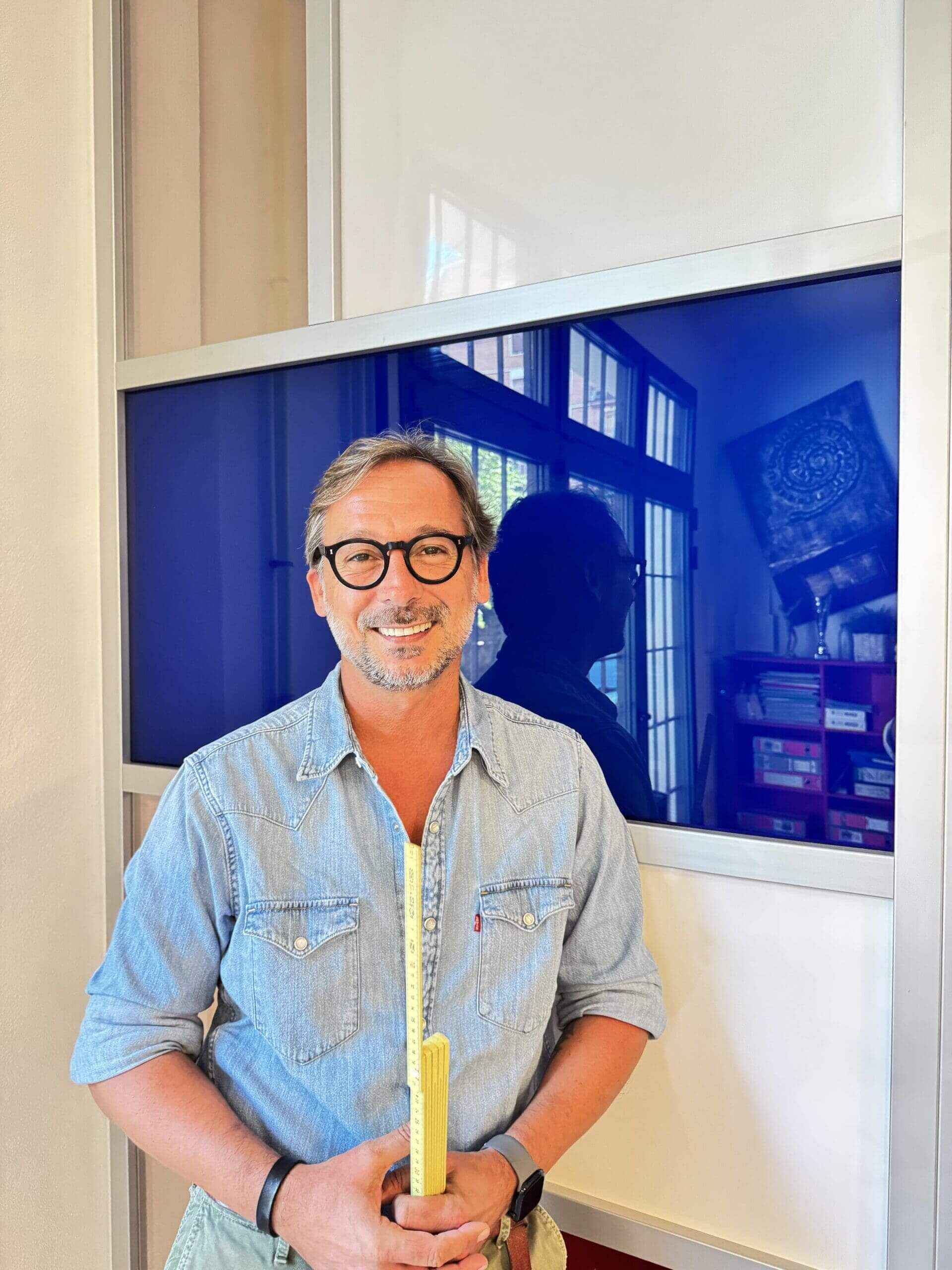 Alessandro Casabianca, agente immobiliare a Bologna, con metro pieghevole simbolo di precisione e attenzione ai dettagli.